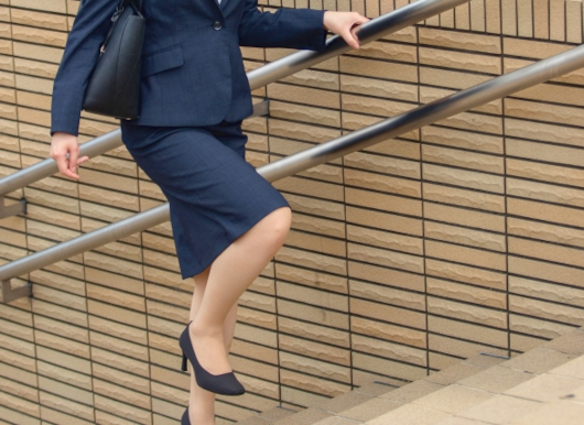 スーツで階段を上る女性