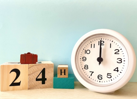 「24H」と書かれた木製のブロックと、置時計