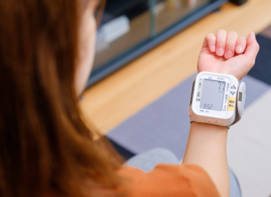 手首式血圧計で血圧を測定する女性