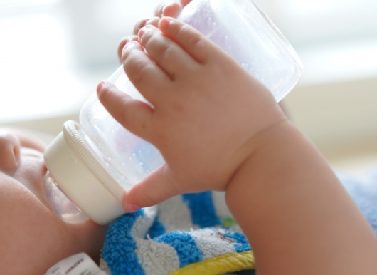 哺乳瓶でミルクを飲む乳児