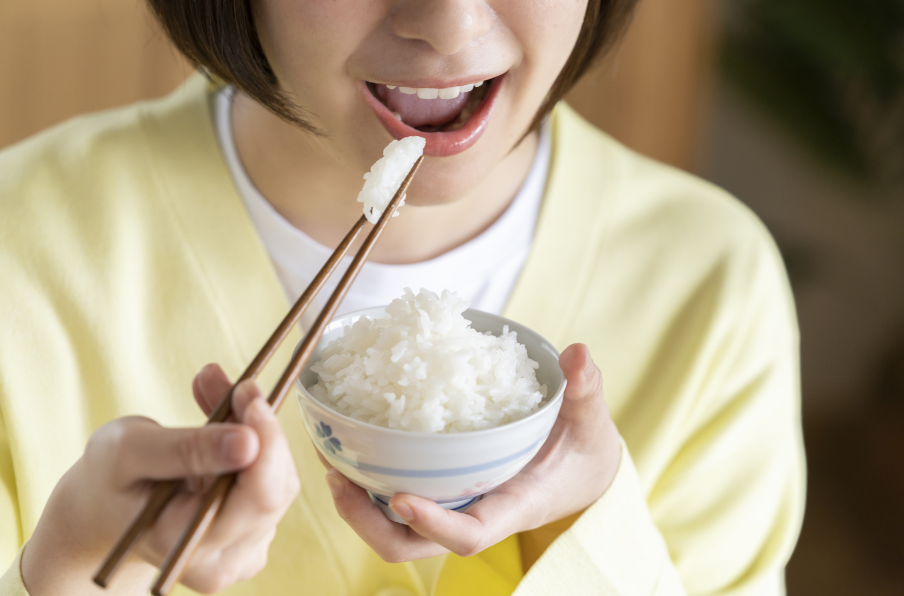 糖質が豊富な白米を食べている女性