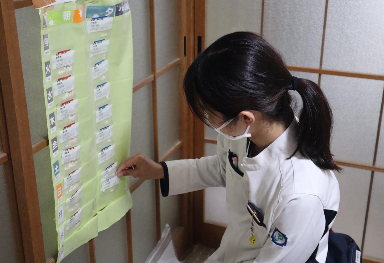 日本調剤の薬剤師がお薬カレンダーに薬をセットしている様子
